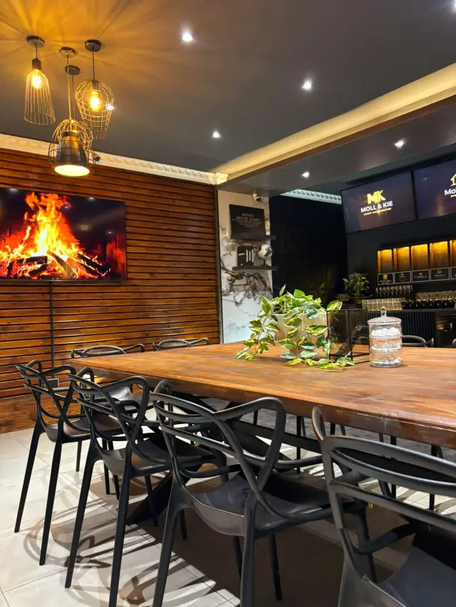 Timber boardroom table with designer chairs and a large display screen at the Moll & Kie conference centre in Burgersfort