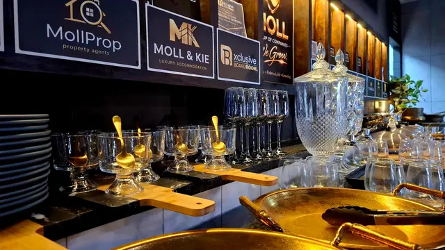 Refreshment station with crystal decanters and gold serving trays in the Burgersfort boardroom