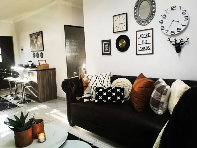Corporate accommodation lounge in Burgersfort with leather Chesterfield couch and statement wall clocks