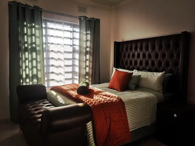 Executive bedroom with tufted headboard and plush linen in a Burgersfort corporate unit