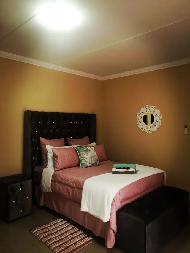 Double bedroom with tufted headboard in an overnight accommodation unit in Burgersfort